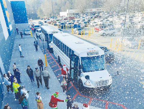 Photos by Anngee Quinones-Belian/Staff Correspondent  Walmart provided a snowy welcome to local kids participating in the Shop with a Cop program on Saturday. Children exiting buses and ready to shop were greeted by Santa and the Grinch under a flurry of festive powder.