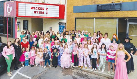 Michelle Bradbeer/Staff Correspondent Ladies from the Murphy School of Dance were dressed for the colorful part on Nov. 22 at the Henn Theatre in downtown Murphy while watching a showing of the new movie Wicked: For Good, the second part of last year’s blockbuster, while wearing Wicked colors of pink, green and black. At far left are Abbigayle Sutton (pink and green, tumbling instructor) and Torie Westmoreland (all black, owner and director of the local dance academy). At far right are Emily Cook (pink gown