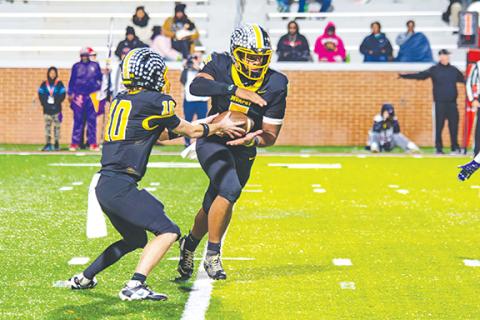 Cannon Crompton/sports@cherokeescout.com Murphy quarterback Brady Grant (left, No. 10) hands the ball off to Cameron Clem (No. 5) in the state 2A championship game Saturday in Hickory. 