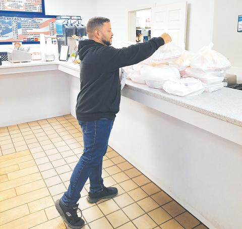 Photos by Anngee Quinones-Belian/ Staff Correspondent  Matthew Crawford was prepared to hand out as many Thanksgiving Day dinners as needed on the holiday Thursday. Folks were going inside as well as pulling into the drive through at Main Street to pick up their meals.
