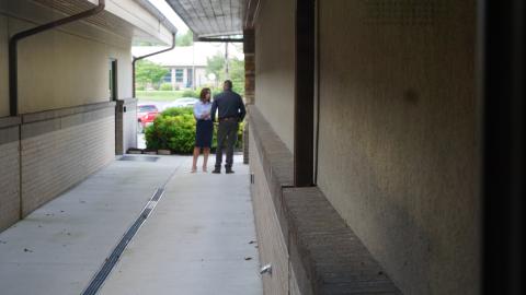 District Attorney Ashley Welch, left, and Cherokee County Sheriff Dustin Smith confer privately before a press conference following the death of Detention Officer Francisco Flattes allegedly at the hands of an escaped inmate in June 2025 at Tri-County Community College. 