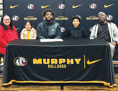Heather Watson/ Contributing Photographer Murphy High School senior Janthony Gooden (middle) signed a letter of commitment to continue his football and academic career at Catawba College in Salisbury. The standout lineman signed the letter on Feb. 4. Janthony is joined by (from left) Angela Gooden, Nova Gooden, Neiko Gooden and Anthony Gooden.
