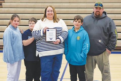 Cannon Crompton/sports@cherokeescout.com At Hiwassee Dam’s game on Jan. 27, the school honored late coach Leon Green. Green coached in Cherokee County for 25 years, primarily at Hiwassee Dam, before retiring in 2024 and passing away on July 29, 2025. Hiwassee Dam athletics honored him with a plaque presented to his daughter, Stacy Van Buskirk (middle). She was joined by (from left) daughter, Zella Van Buskirk, son Remington Van Buskirk, son Noah Van Buskirk and husband Nathaniel Van Buskirk.