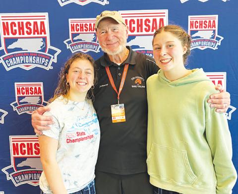 Chris Crayton/Contributing Photographer Tri-County Early College swimmers Fern Crayton (left) and Sophia Evans (right) competed at the state meet on Feb. 14 in Cary. The team is coached by Frank Bachteler (middle).