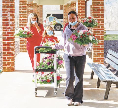 Photos by Michelle Bradbeer/Staff Correspondent Andrews Florist brought colorful flowers to Valley View Care & Rehabilitation Center on Friday after masking up due to COVID and flu outbreak at the facility. Thanks to local residents making generous donations, 12 special tabletop flower arrangements and five vases were delivered to staff and patients Friday. Florist Christy Reeves and assistants Eloise Mason, Bethony Allen and Keyari Allen decorated the cafeteria and recreation room for patients, while the n