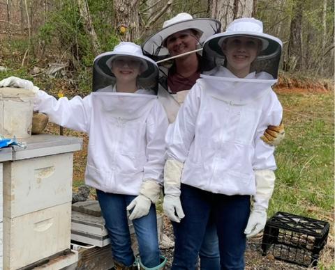 Cameron Green enjoys beekeeping with her children and has made the activity a family affair. The three just installed a new package of bees after the girls finished their first beekeeping class. From left are Kalette, Cameron and Danika Green.