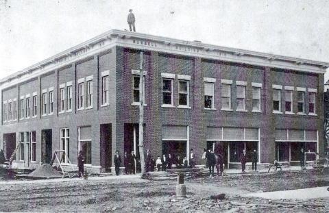 The Russell Hotel was built in the early 1900s by Mayor David Samuel Russell on the corner of Locust and what today is Main Street, where the mayor operated a general store on the main level and a hotel on the second floor. In this photo, the mayor is standing on top of the building as it was nearing completion.  