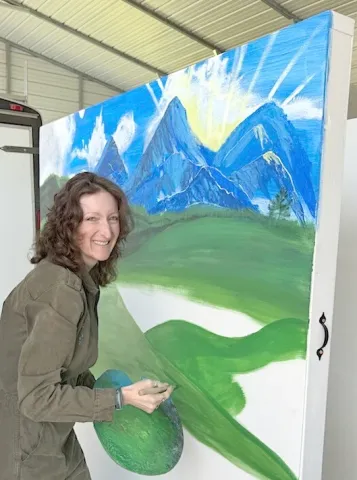 Sammi Crow paints a backdrop for the upcoming event at Shepherd of the Mountains Church. The fundraiser on April 30 will involve song and dance clips from popular movies by students at Shepherd Academy.