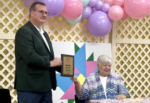 Murphy Mayor Tim Radford (left) shares stories that highlight the ways Nancy Helms (seated) has worked to make Cherokee County a better place.