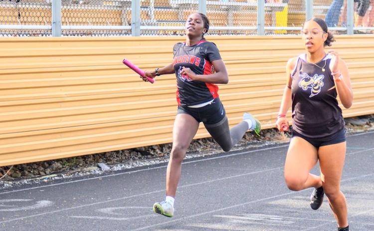 Juliet Holloway (left) of Andrews competes in the 4x200-meter relay at Hayesville on April 1.