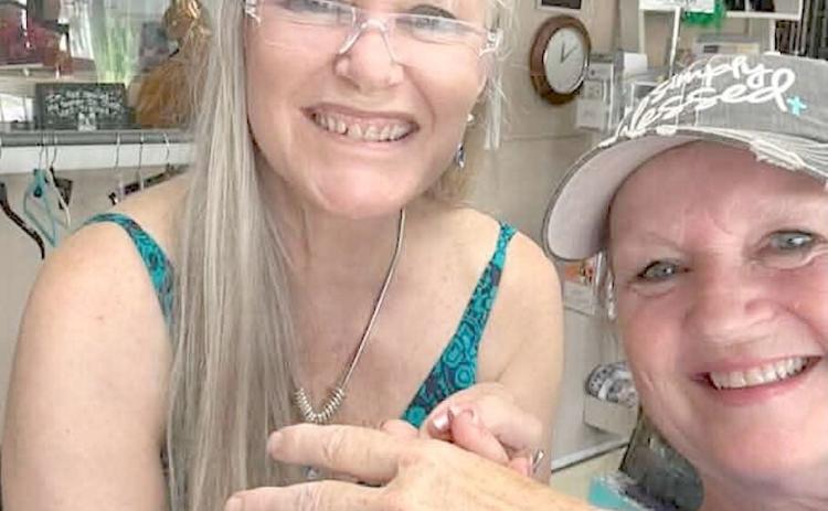 A chance discovery led to a happy reunion as Lisa Pursel, left, a cashier for 25 years, presents a long-lost class ring to its original owner, Veronica Flood. The ring, found among donated items at the Valley River Humane Society Thrift Store, is once again where it belongs. Photo contributed by Veronica Flood
