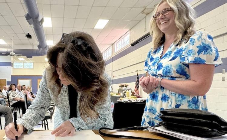 Angel Owens, left, signs paperwork after taking the oath of office as Cherokee County's new superintendent of schools. A reception was held at Cherokee County Schools home office in Marble on June 30. The Cherokee County Board of Education selected  Owens as the School System's new superintendent during its meeting on May 21, 2026. Owens repaced Dr. Keevin Woody, who served as the superintendent since Nov. 1, 2022. Photo by Randy Foster/editor@cherokeescout.com