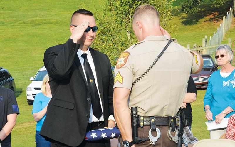 Detective J.J. Wooten receives the burial flag after Deputy K-9 Ajax was laid to rest. 