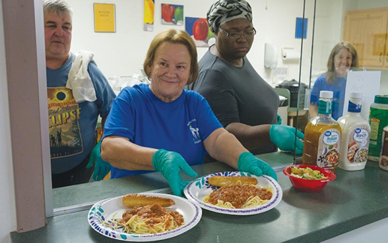 Nancy Allen offers up spaghetti plates during Appalachian Angels’ Spaghetti Dinner last year.