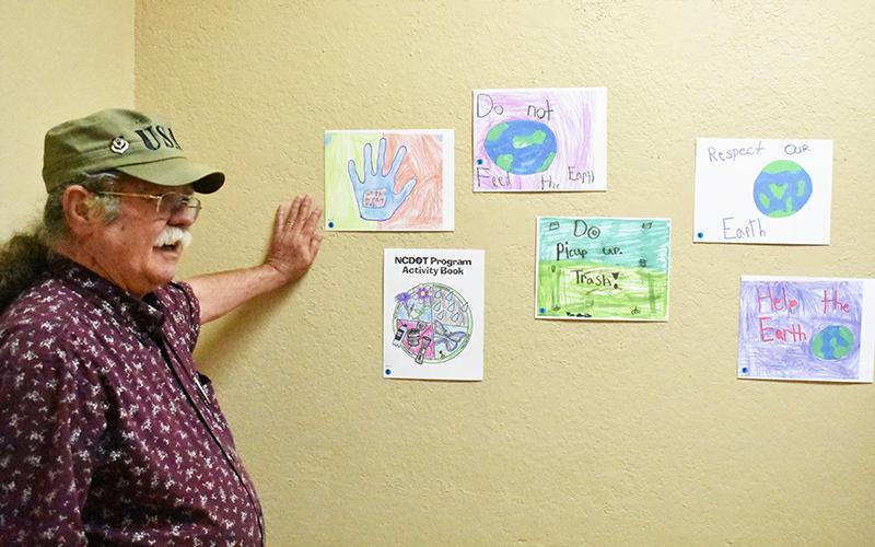 David Vowell shows off some of his favorites from the anti-litter posters on display at the Murphy Art Center this month.