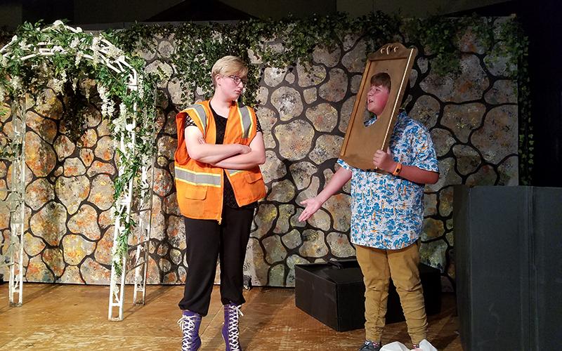 While doing her mandated community service, the Wicked Queen, played by Grace Allen, finds her Magic Mirror, played by Kencade Watkins, in the trash.