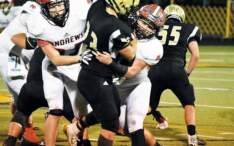 Andrews’ Jimmy Miller wraps up Hayesville’s Blake McClure during Friday night’s game.