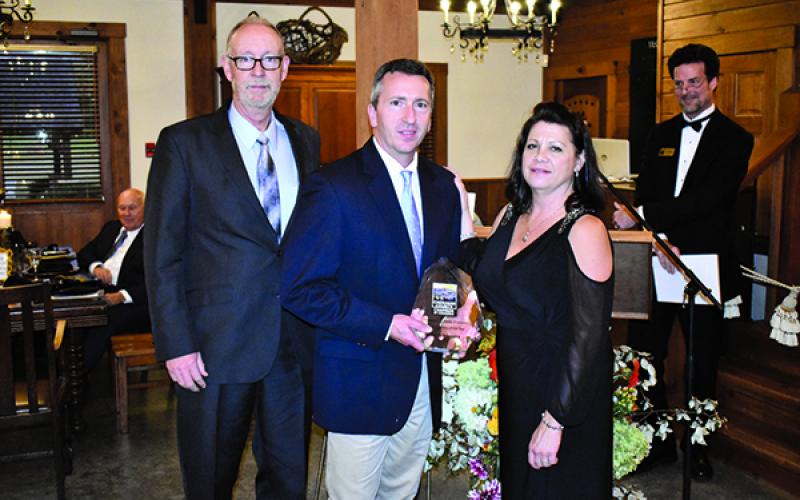 Farley Insurance associates Scott Freel (left) and Rod Brown accept the award for the 2019 Cherokee County Chamber of Commerce Business of the Year from chamber Executive Director Sherry Raines.