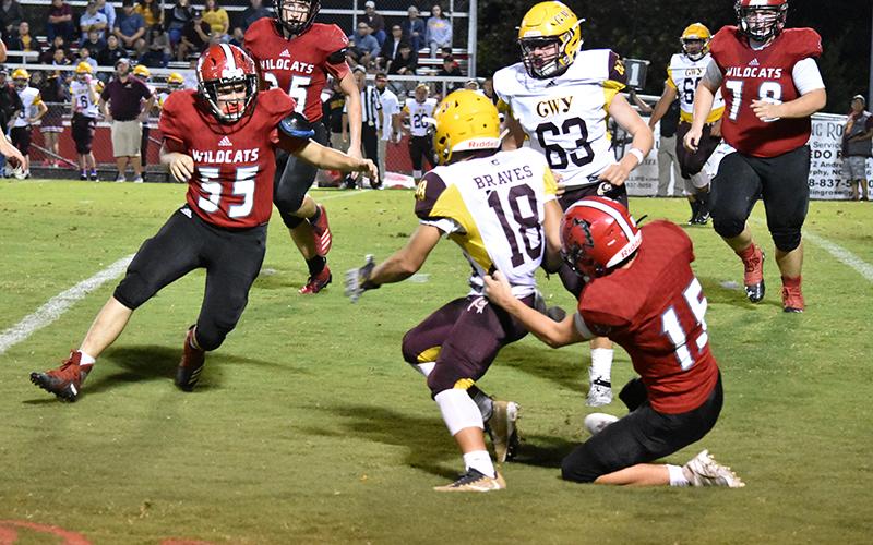 Gavin Wilson brings down a ballcarrier as Harley Crawford (55) closes in during Friday's win over Cherokee.