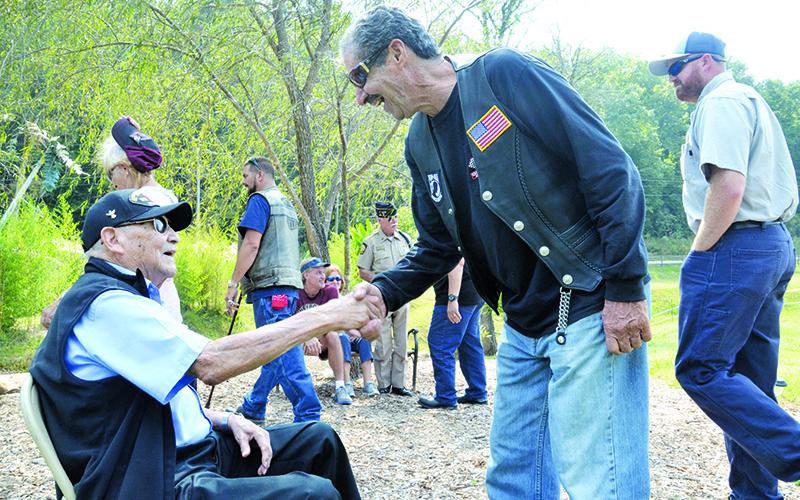 Patrons at the Veterans Educational Appreciation Day event show respect to 93-year-old U.S. Army veteran Reuben Taylor (left), who fought in the European Theatre of World War II.