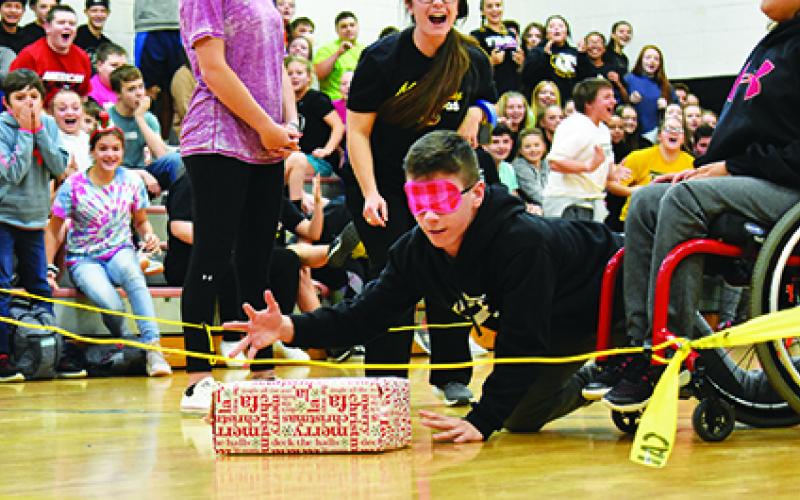 Murphy Middle School student Trenton Russell reaches for a package in Blindfold Musical Chairs. Photo by Samantha Sinclair