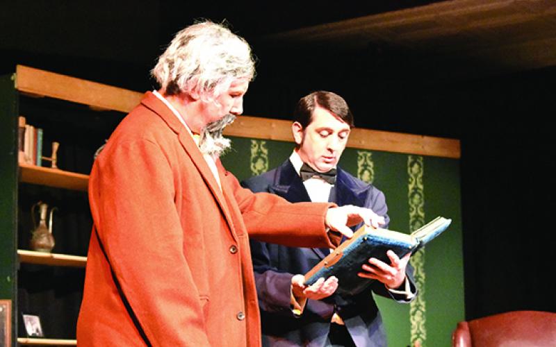 In A Perfect Likeness, Eric West (right) as Charles Dodgson shows Bill Butler as Charles Dickens photos of a young girl named Alice. The play will be shown Saturday night. Photo by Samantha Sinclair