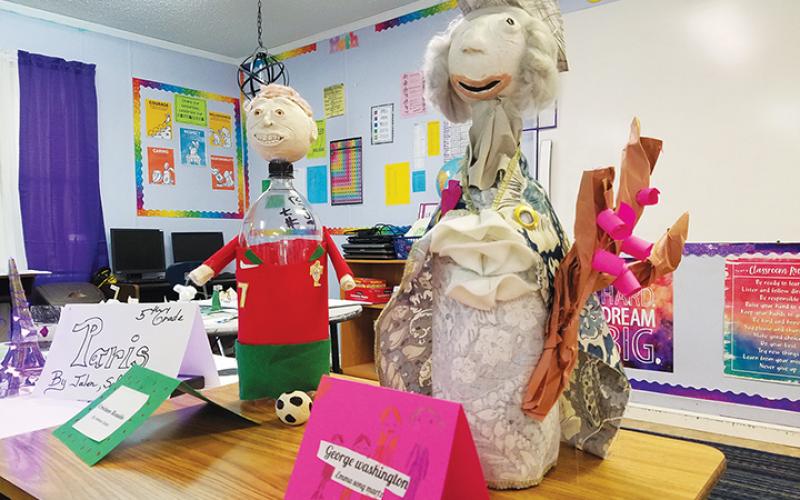 Carrie Dyer led her fourth-grade students at The Learning Center in making biography bottles. Students picked who they wanted to research, like Cristiano Ronaldo and George Washington, then sculpted faces with clay to be attached to dressed soda bottles. Photo by Samantha Sinclair