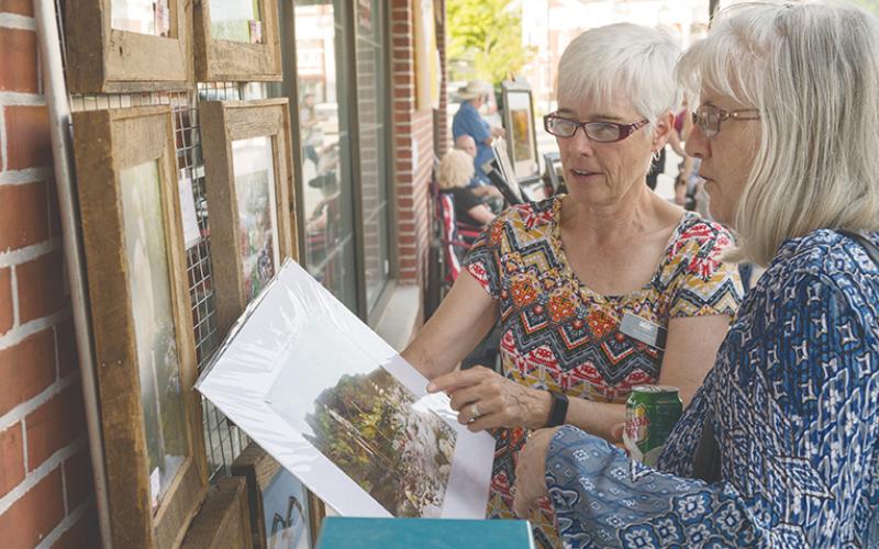 Kelly Kennon (left) explains to Sherry Barnes how she came upon a grouping of stacked water cairns on Fires Creek during last year’s Murphy Art Walk.