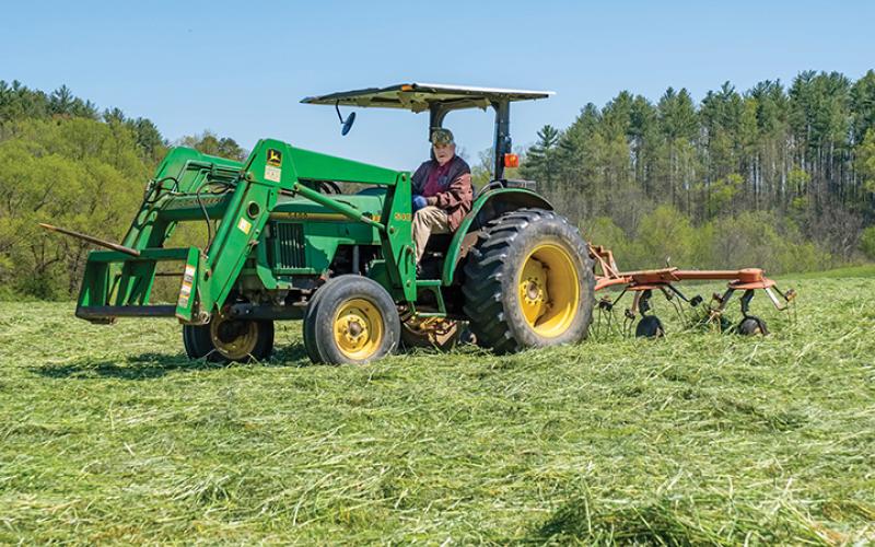 Ralph Myers, who will be 96 in September, still runs the John Deer tractor on his farm. He served in Europe during World War II as an anti-tank gunner. He was cutting hay, and will come back to roll it later, at John C. Campbell Folk School in Brasstown. Photo by Sam Jokich