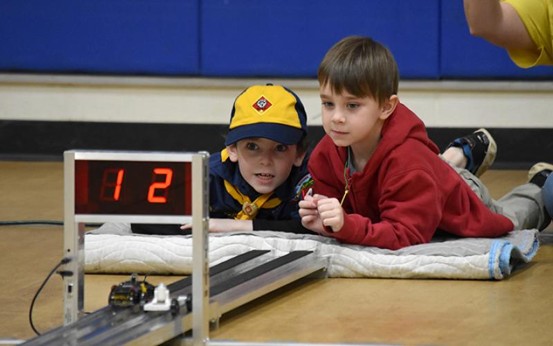 Two Cub Scouts watch the race from the finish line. Photo by Samantha Sinclair