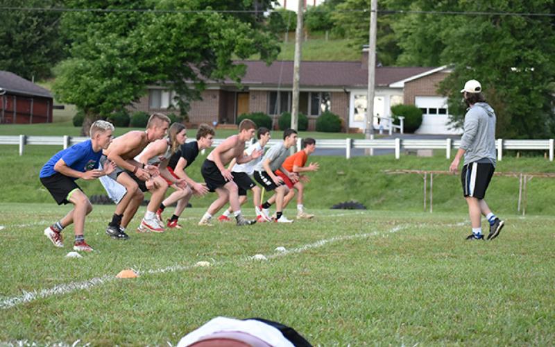 Andrews football assistant Matthew Maennle runs the Wildcats defensive backs (spaced 6 feet apart) through coverage drills during workouts on June 16. Photo by Noah Shatzer