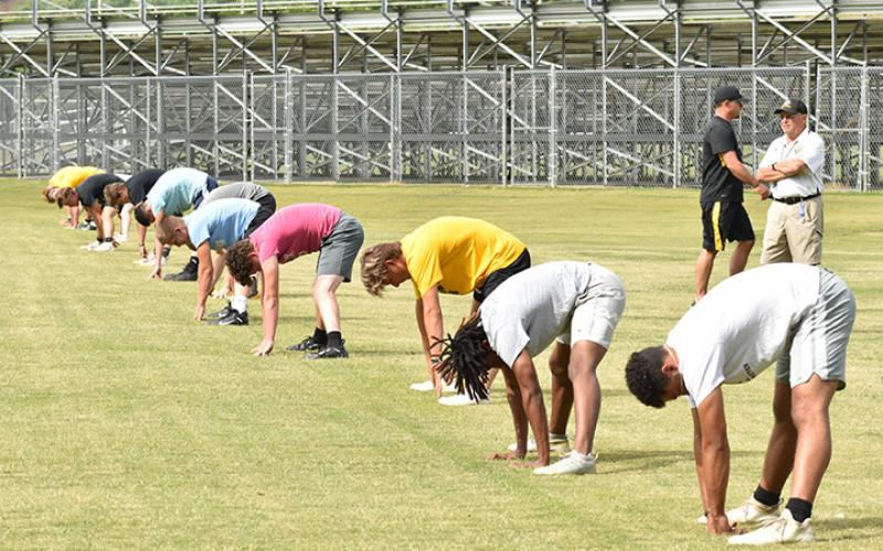 Murphy coach David Gentry watches as the Bulldogs skill players spread out and stretch prior to conditioning drill work during the first week of workouts on June 17. Photo by Noah Shatzer