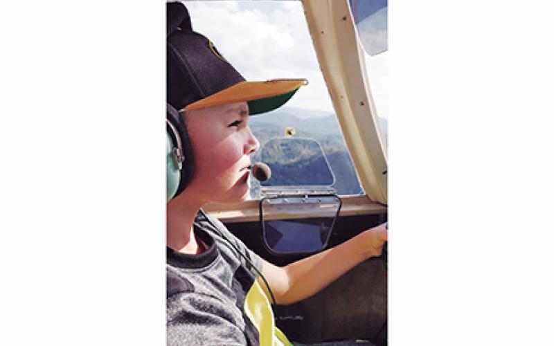 Timothy Raxter flies a plane for the first time with assistance from airport manager Garland Trull. The Western Carolina Youth Aviation Foundation is hoping to give more kids the same opportunity Raxter had.