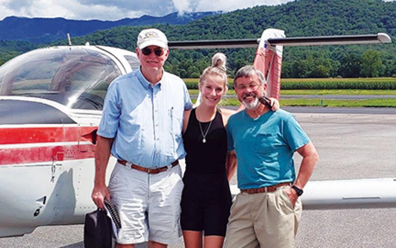 Mary Deatrick celebrates getting her private pilot license with designated pilot examiner John Dennis and instructor Joe Rybicki.