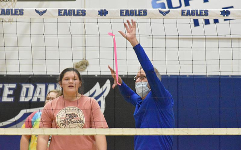 Second-year Hiwassee Dam High School volleyball coach Sam Walker demonstrates a spiking techniquie to senior newcomer Katie Gibson during the Lady Eagles’ team practice Monday. 