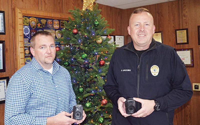 Penny Ray/pennyray@cherokeescout.com Murphy assistant police chief Dustin Smith and Police Chief Justin Jacobs demonstrate the department’s new body cameras.