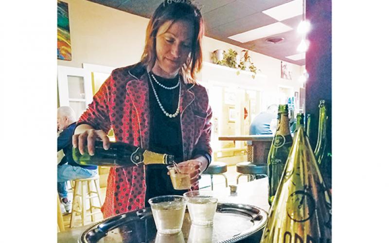 Lane Schreiber, owner of The Daily Grind & Wine in Murphy, pours champagne to hand out to guests during the 2019 New Year’s Eve celebration. Photo by Samantha Sinclair