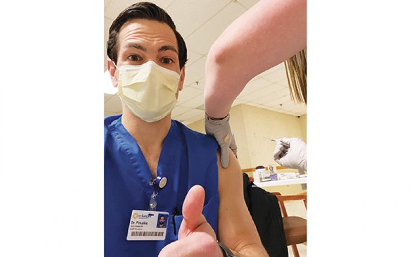 Dr. Terry Fokakis gives a thumbs-up as he takes a COVID vaccination selfie.