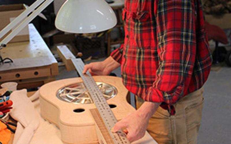Stacy Van Buskirk/svanbuskirk@cherokeescout.com Mike Conner of Murphy tests the fit of the spider resonator cone in his handmade Dobro. It’s important that the parts fit snugly, not too tight, and the alignment is just right.