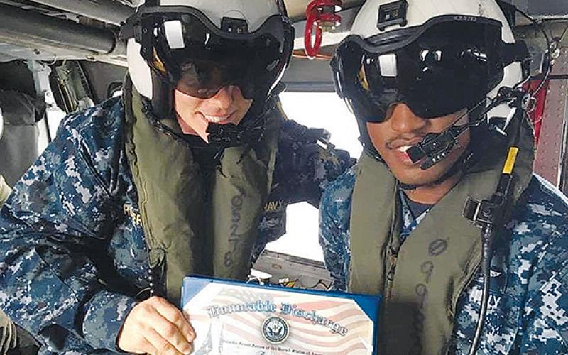 Murphy High School graduate Greg Lloyd does his re-enlistment in a helicopter over Tokyo. “You are discharged, then sign a new contract,” the Navy Blue Angel said.