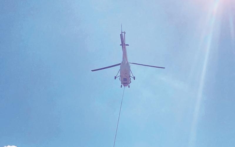 A helicopter with the National Transportation Safety Board flies in wreckage from the Oct. 3 plane crash to Western Carolina Regional Airport on Friday.