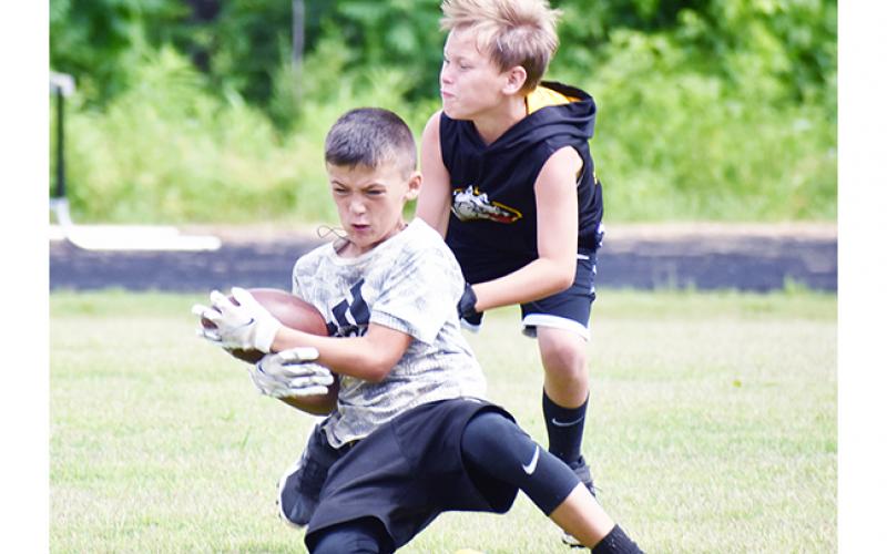 Justin Fitzgerald/sports@cherokeescout.com A total of 47 kids from age 7 through rising ninth-graders attended Murphy’s youth football camp from May 31 until Friday. Above, Wyatt Coleman steps in front of Brady Watson to break up a pass.