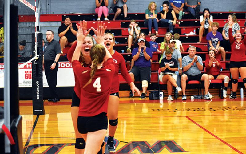 Andrews’ Rylie McDonald high-fives Kylie Donaldson after winning a point against Hiwassee Dam on Aug. 22.