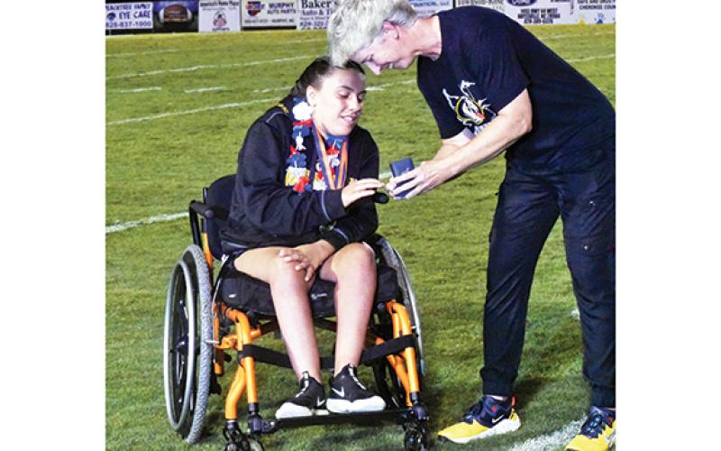 Murphy girls track and field head coach Penny Johnson gives Murphy’s Jordan Oliver her state championship ring at halftime of the Bulldogs’ football game against Franklin on Aug. 19. Oliver, a junior, won the 55-meter wheelchair dash at last year’s indoor track and field state championships as well as the 100-meter dash at the outdoor track and field state championships.