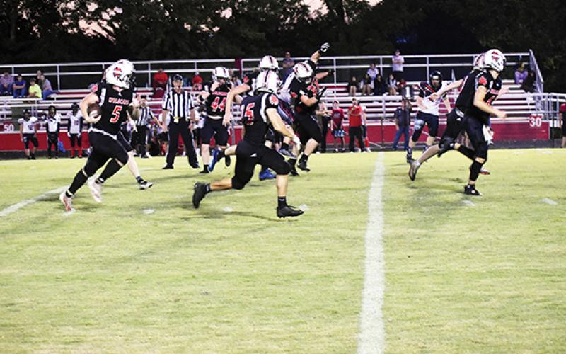 Justin Fitzgerald/sports@cherokeescout.com Andrews’ Austin Martin runs down the field after intercepting a pass, while a host of Wildcats lead the way Friday night in a 62-0 home victory over the North Georgia Falcons.