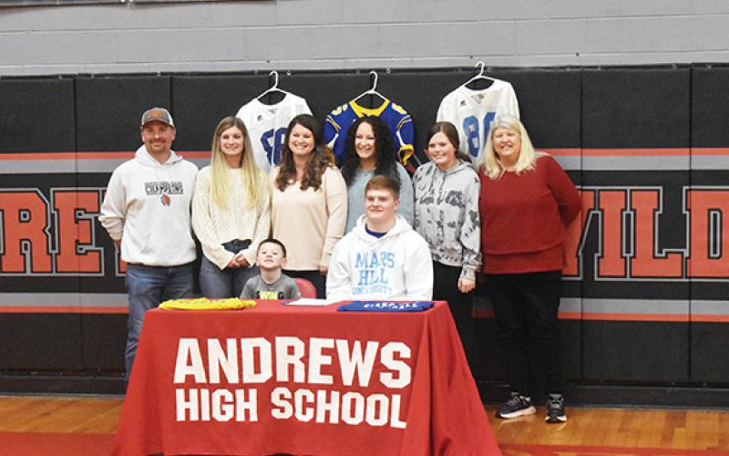 Justin Fitzgerald/sports@cherokeescout.com Andrews standout Isaac Weaver signed a National Letter of Intent to play football at Mars Hill University on Feb. 1. Pictured in the photo are (sitting) Weaver and his brother Blake (left); standing are Amos Weaver (father), Ashlyn Weaver (sister), Stephanie Weaver (mother), Alexis Finley (sister) Ava Pressly (cousin) and Kathy Pressley (grandmother).