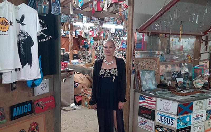Nakoda Abernathy stands in the doorway of her father’s shop at Decker’s Flea Market during his memorial service on May 28.