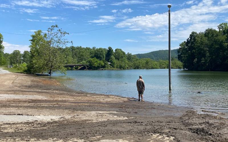 Photos by Mark Kephart/Contributing Photographer John Wooten looks over a hard day’s work while Australian Blue Heeler Rowdy cools off in Lake Hiwassee after Wooten and Mark Kephart cleaned out all of the debris.