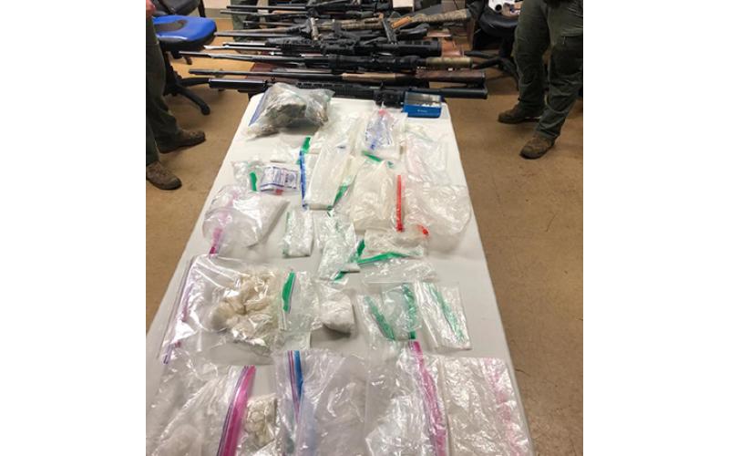 Cherokee County Sheriff’s Office An evidence photo shows weapons and suspected drugs seized by local law enforcement.