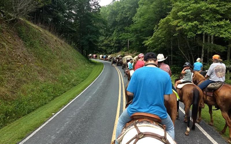 The Western North Carolina Wagon Train rounds a curve in Mineral Bluff, Ga., during this year’s summer ride.